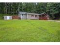 Spacious front yard showcasing a well-maintained lawn, a shed, and the side view of the home at 4670 Brookwood Dr, Cumming, GA 30041