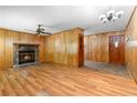 Cozy living room featuring a stone fireplace, wood paneling, and hardwood floors at 501 Samaritan Dr, Cumming, GA 30040