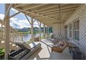 Enjoy a relaxing view of the lake from this back patio featuring a lounge chair, swing, and dining area at 4520 Odum Lake Trl, Cumming, GA 30040