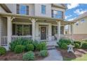 Inviting front porch with white columns, brick accents, and lush landscaping. Perfect for relaxing outdoors at 4520 Odum Lake Trl, Cumming, GA 30040