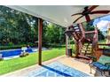 Covered back porch featuring a ceiling fan, staircase, and view of the pool and backyard at 2068 Tribble View Way, Lawrenceville, GA 30045