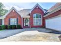 Traditional brick home with black shutters, an attached garage, arched window, and a well-maintained lawn at 2068 Tribble View Way, Lawrenceville, GA 30045
