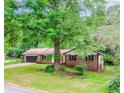 Charming ranch-style home boasting a brick exterior, attached garage, and a spacious front yard with mature trees at 3156 Laurel Way, Snellville, GA 30078