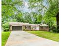 Beautiful brick home with attached garage, green lawn, and a welcoming front porch perfect for enjoying the outdoors at 3156 Laurel Way, Snellville, GA 30078