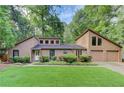 Inviting home featuring an attached two-car garage, mature trees, and a well-kept front lawn at 4920 Tremont Ne Dr, Marietta, GA 30066