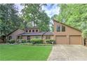 Inviting exterior with a two-car garage, well-maintained lawn, and mature trees at 4920 Tremont Ne Dr, Marietta, GA 30066