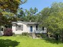 Quaint one-story home featuring a well-maintained lawn, mature trees, and a welcoming front entrance at 881 Mclinden Se Ave, Smyrna, GA 30080