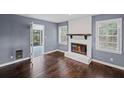 Inviting living room with refinished hardwood floors, brick fireplace, and bright windows with shutter-style blinds at 881 Mclinden Se Ave, Smyrna, GA 30080