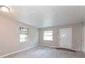 Bright living room featuring neutral paint, two windows, and a white entry door at 1079 Stonewall Drive Southeast, Atlanta, GA 30315