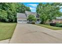 Lovely home with an attached two-car garage and a long driveway, surrounded by green trees at 3158 Crestmont Nw Way, Kennesaw, GA 30152