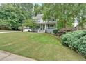 Beautiful home exterior featuring a well-kept lawn and mature trees surrounding the property at 3158 Crestmont Nw Way, Kennesaw, GA 30152