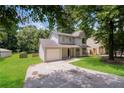 Two-story home featuring gray siding, a well-maintained lawn, driveway, and mature trees at 5107 Rails Way, Norcross, GA 30071