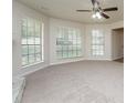 Spacious living room with neutral carpet, large windows, and a ceiling fan at 5107 Rails Way, Norcross, GA 30071