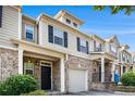 Two-story townhome exterior with brick accents, siding, and individual garages at 2725 Morgan Glen Rd, Buford, GA 30519