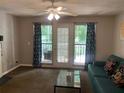 Cozy living room with natural light, fan, and a blue sofa near a window overlooking trees at 3515 Shepherds Path, Decatur, GA 30034