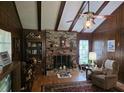 Wood-paneled living room featuring a brick fireplace and beam ceiling at 529 Valley Woods Se Cir, Conyers, GA 30094