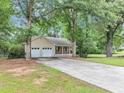 Traditional home with a long driveway, a covered porch, and a two-car garage at 250 Daileys Plantation Dr, Mcdonough, GA 30253