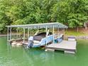 Covered boat dock on the lake featuring a boat, jet ski, and storage, perfect for waterside fun at 6900 Driskell Cir, Cumming, GA 30041