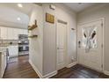 Inviting entryway and view into kitchen, showcasing wood floors and modern design elements at 1244 Harris Commons Pl, Roswell, GA 30076