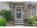 Close-up of the front door with stone surround and decorative wreath, creating a welcoming entrance at 1244 Harris Commons Pl, Roswell, GA 30076