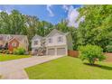 Beautiful two-story home with a well-manicured lawn and a two-car garage, set amongst lush trees at 3781 Deercreek Dr, Powder Springs, GA 30127