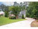 Beautiful brick home with a curved driveway, well-maintained lawn, and mature trees providing ample shade at 1587 Red Fox Sw Run, Lilburn, GA 30047