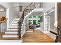 Elegant foyer boasts hardwood floors, staircase with iron spindles, and an abundance of natural light at 2845 Aquitania Ln, Cumming, GA 30040