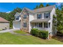 Beautiful two-story home with stone accents, a covered porch, and a well-maintained lawn and landscaping at 684 Doe Lane Ln, Loganville, GA 30052