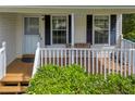 Inviting front porch featuring a wooden deck, decorative railing, and charming accents with black shutters at 684 Doe Lane Ln, Loganville, GA 30052