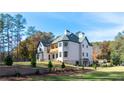 Expansive backyard of an elegant two-story home featuring a patio and lush landscaping at 10745 Shallowford Rd, Roswell, GA 30075