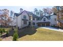 Majestic brick home with a three-car garage and professionally landscaped lawn at 10745 Shallowford Rd, Roswell, GA 30075