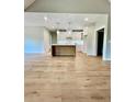 Kitchen with island, recessed lighting, white cabinets, stainless appliances, and hardwood floors at 1273 Jersey Social Circle Rd, Covington, GA 30014
