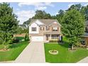 Inviting two-story home boasting a lush green lawn, complemented by mature trees and a welcoming facade at 3962 Roberts Crest Dr, Suwanee, GA 30024