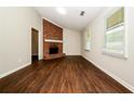 Bright living room with hardwood floors, a brick fireplace, and ample natural light from large windows at 6194 Golden Meadow Court Ct, Riverdale, GA 30296