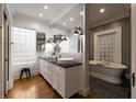 Bright bathroom with dual sinks, sleek fixtures, glass block window, and a luxurious soaking tub at 1656 N Pelham Ne Rd, Atlanta, GA 30324
