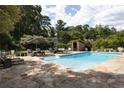 Backyard pool area features stone patio, lounge chairs, and lush landscaping perfect for relaxing outdoors at 1656 N Pelham Ne Rd, Atlanta, GA 30324