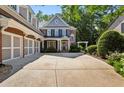 Elegant brick home with a spacious driveway, leading to a covered front porch and three-car garage at 1382 Murrays Loch Nw Pl, Kennesaw, GA 30152