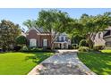 Charming brick home with well-maintained lawn, mature trees, and traditional architectural details at 1382 Murrays Loch Nw Pl, Kennesaw, GA 30152