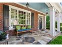 Inviting front porch with stone flooring, comfortable bench seating, and classic architectural details at 1382 Murrays Loch Nw Pl, Kennesaw, GA 30152