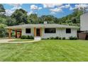 Beautiful one-story home with lush landscaping, covered carport, and inviting curb appeal at 4237 Rickenbacker Ne Way, Atlanta, GA 30342
