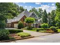Stunning two-story home with a well-maintained lawn, mature trees, and a long driveway leading to the garage at 125 Franklin Pl, Atlanta, GA 30342