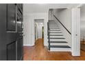 Warm foyer with hardwood floors, staircase, and neutral paint offering a welcoming entrance at 220 Hollyridge Dr, Roswell, GA 30076