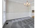 Dining room with a stylish carpet, chandelier, and paneled wall adding charm to this home at 2873 Hilton Nw Cir, Kennesaw, GA 30152