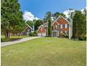 Lovely exterior view of a brick house with a manicured lawn and a long driveway leading to an attached two-car garage at 2873 Hilton Nw Cir, Kennesaw, GA 30152