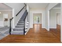 Bright foyer featuring hardwood floors, staircase with black banister, and views into other rooms at 2873 Hilton Nw Cir, Kennesaw, GA 30152