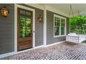 Inviting front porch with a wooden front door, a swing, and a brick floor for a relaxing outdoor space at 2922 Parkridge Ne Dr, Brookhaven, GA 30319
