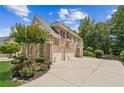 Exterior showcasing a well-manicured lawn, brick accents, a three car garage, and tasteful landscaping at 3088 Hidden Falls Dr, Buford, GA 30519