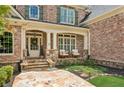 Charming covered front porch with stone accents, seating area, and decorative details, inviting guests inside at 3088 Hidden Falls Dr, Buford, GA 30519