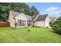 A well kept lawn surrounds this home with with neutral siding and maroon shutters at 1055 Avalon Dr, Lawrenceville, GA 30044
