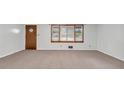 Cozy living room with neutral carpet, window, and diamond pane door at 1189 E Fayetteville Rd, Riverdale, GA 30296